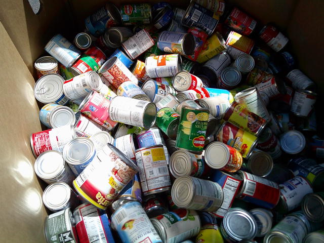 Various cans in a cardboard container.